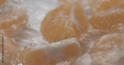 Fruit drop in water splashing in slow motion tangerine