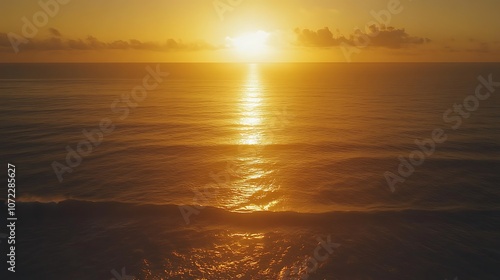 A tranquil sunset over the ocean, casting a golden glow on the water and reflecting serene hues in the sky.