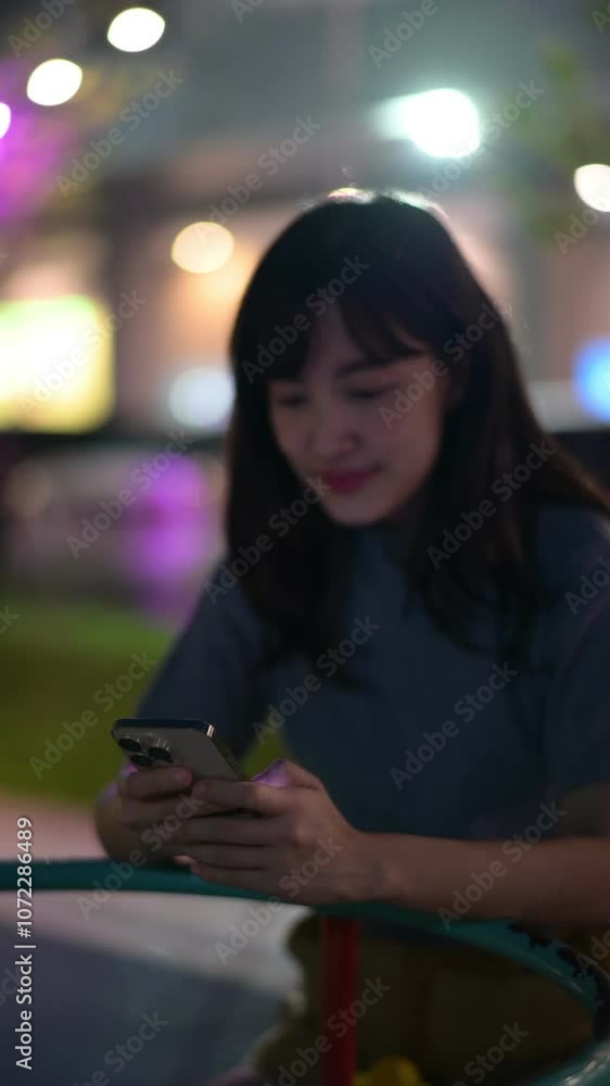 Vertical video of Woman Smiling with Phone at Night Colorful Lights, Outdoor Technology, and Communication for Happiness in Urban Setting Vertical video of Woman Smiling with Phone at Night Colorful Lights, Outdoor Technology, and Communication for Happiness in Urban Setting