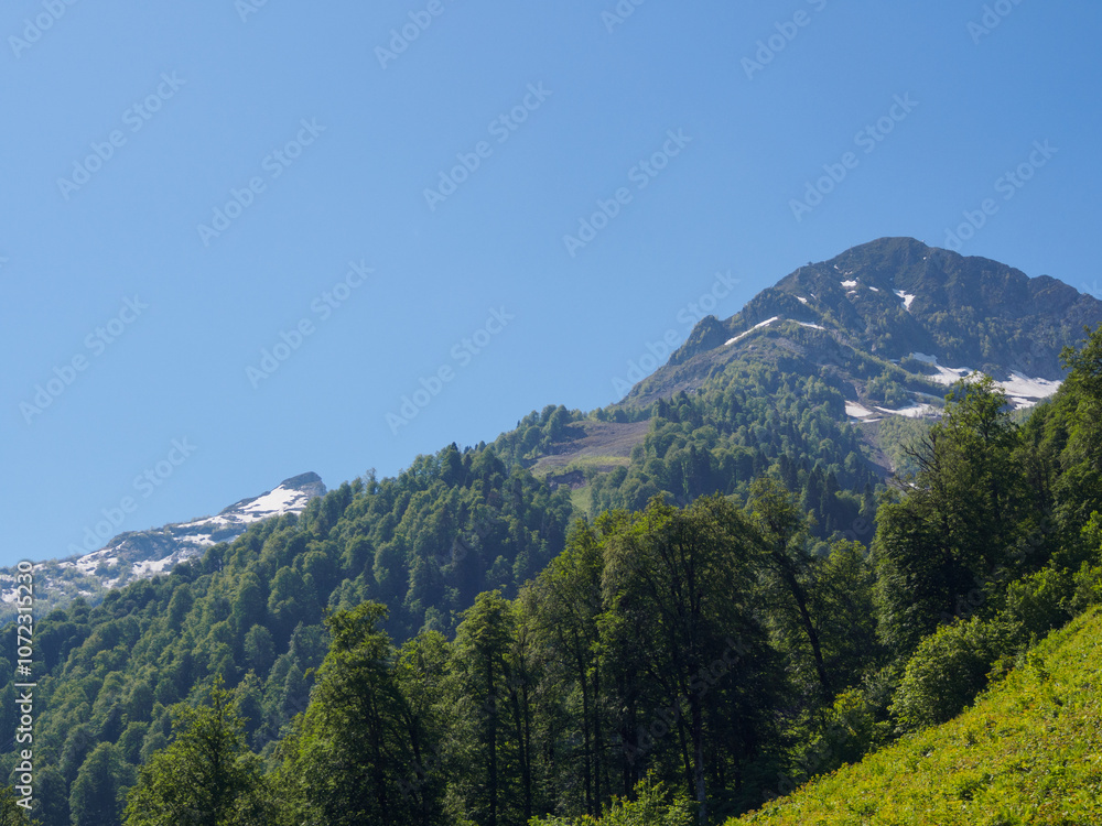 Obraz premium Epic mountain ranges twisting under the sun, with vibrant slopes and cloud shadows, embody the strength and beauty of nature