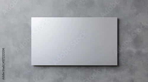 A sleek, blank metallic panel against a textured gray background, emphasizing minimalism and modern design.