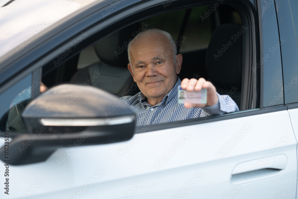 Elderly Man Proudly Displaying Driver’s License from Car Window Elderly Man Proudly Displaying Driver’s License from Car Window