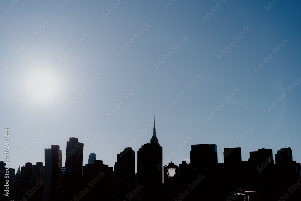 Naklejka premium Silhouette of a City Skyline at Sunset Over the Rooftops and Nature