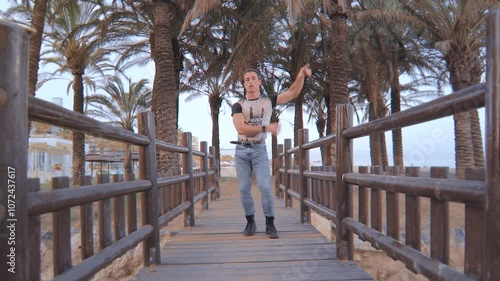 Modern Funk Dancer on a Wooden Bridge with Palm Trees in the Background. Bailarín de Funk Moderno en un Puente de Madera con Palmeras de Fondo