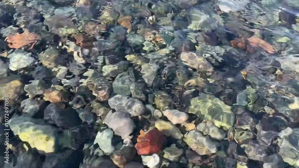 in summer in Georgia, the sea wave rolls over the colorful pebbles on the Black Sea coast in summer in Georgia, the sea wave rolls over the colorful pebbles on the Black Sea coast