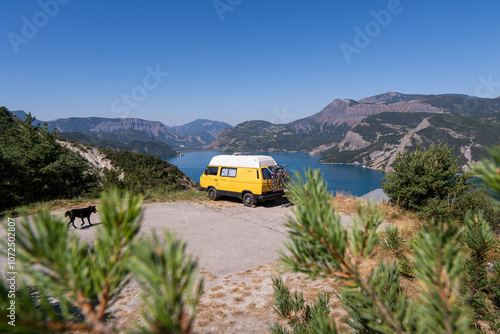 Retro camper van parked on the cliffs with the view of Serre-Poncon lake, Ecrins national park, France