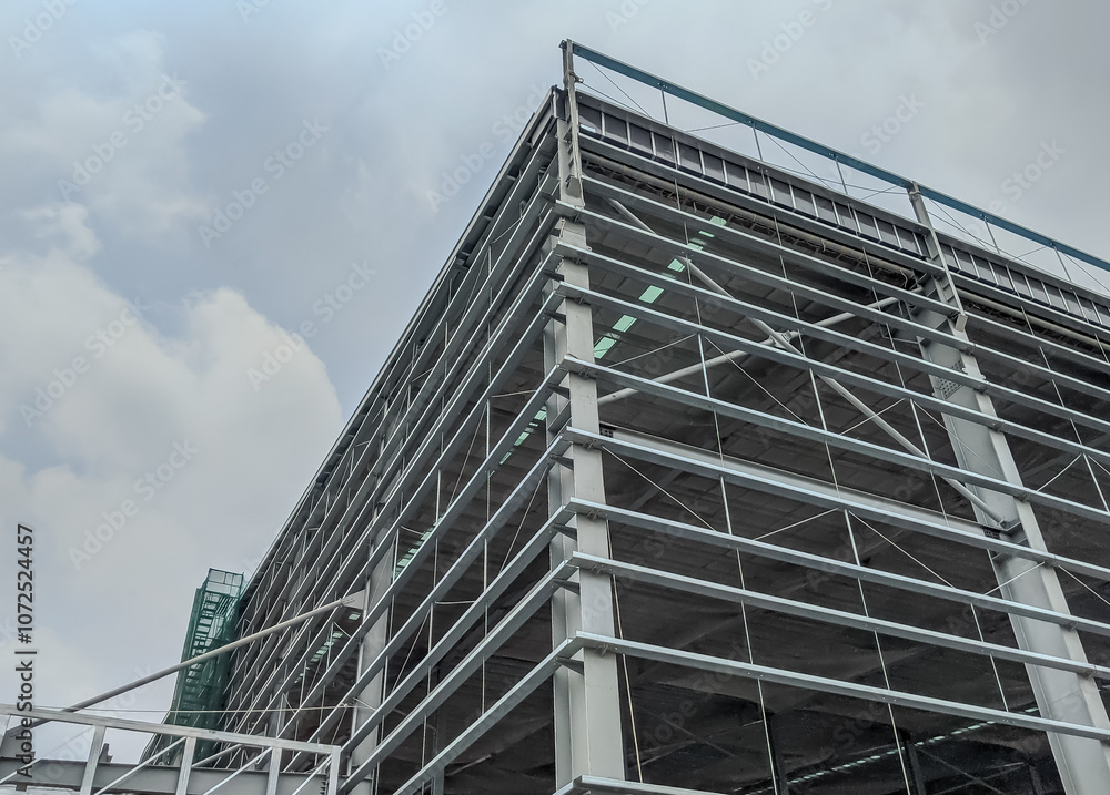 Steel frame structure, steel frame workshop is under construction against a blue sky, blue steel in steel installation construction. Steel frame structure, steel frame workshop is under construction against a blue sky, blue steel in steel installation construction.