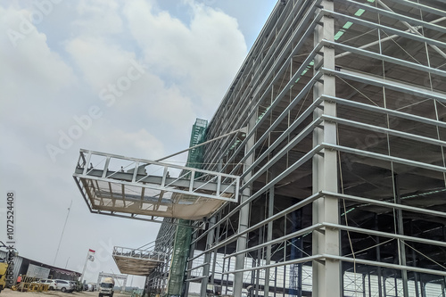 Steel frame structure, steel frame workshop is under construction against a blue sky, blue steel in steel installation construction.