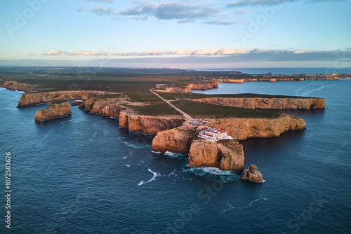 The lighthouse of Cabo de São Vicente and fort ruins at sunset. Aerial view from the ocean