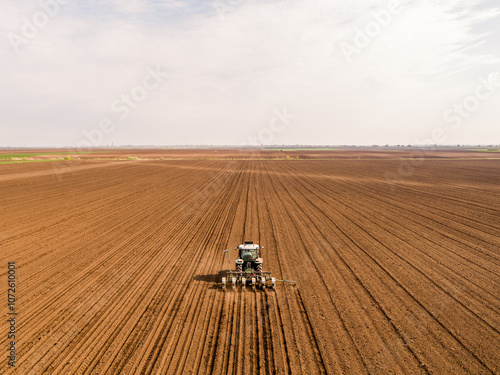 Tractor seeding in cultivated field, precision agriculture at its best photo