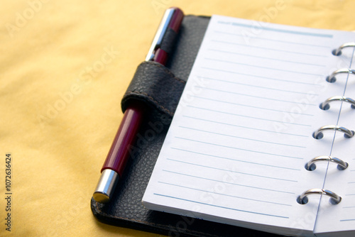 close up  of an open daily brown calendar with silver rings isolated on white background. selective focus