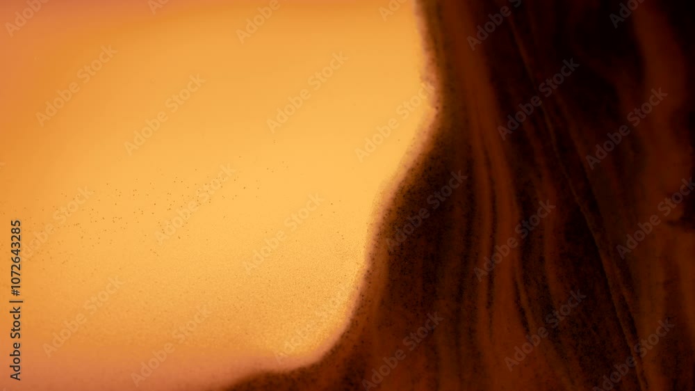 Abstract macro shot of small grains of sand falling down in slow motion. 