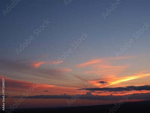 Vivid orange sunset sky with sun setting in the distance, creating a panoramic view, evening, colorful