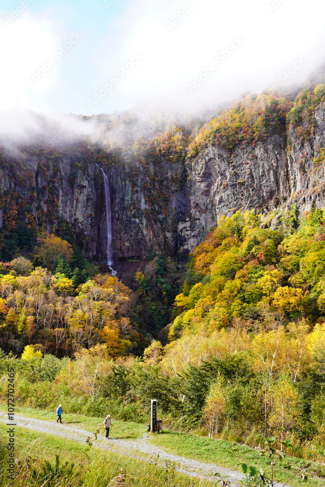 米子大瀑布の秋、紅葉と霧に包まれた滝の絶景