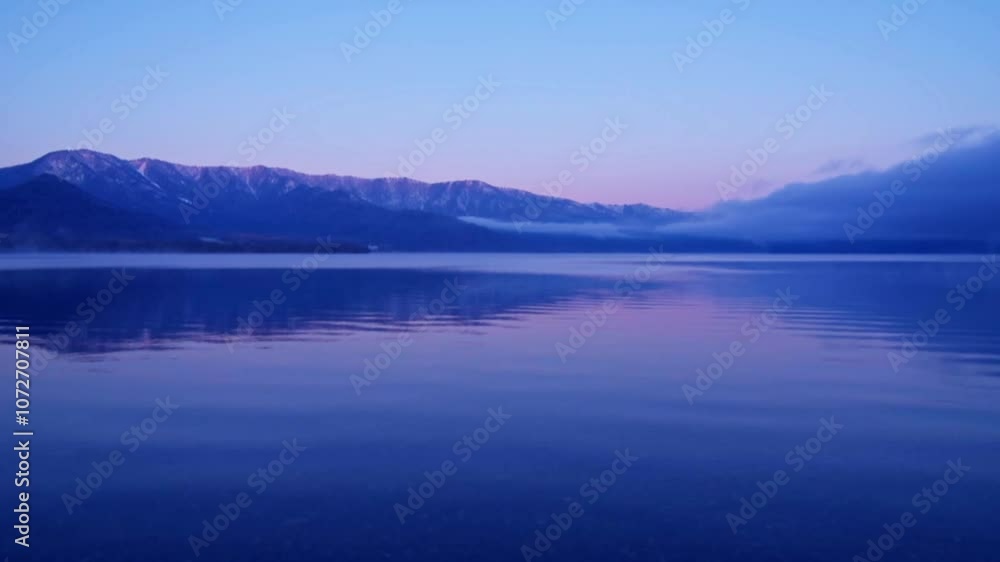 淡いグラデーションの夜明けの湖。水面に穏やかなさざ波。北海道の屈斜路湖。 淡いグラデーションの夜明けの湖。水面に穏やかなさざ波。北海道の屈斜路湖。