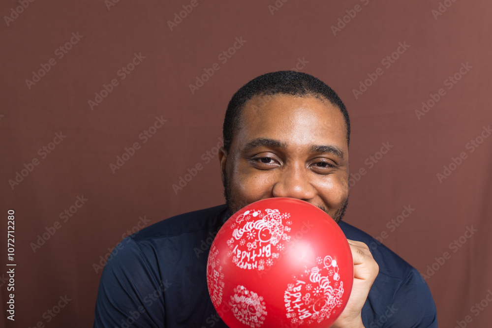 A red happy birthday balloon, man blowing a red birthday balloon A red happy birthday balloon, man blowing a red birthday balloon
