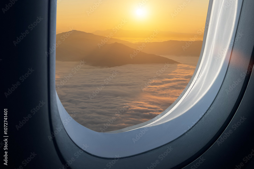Airplane flying low over foggy mountains, view from plane window of plane wing and sky sunrise Airplane flying low over foggy mountains, view from plane window of plane wing and sky sunrise