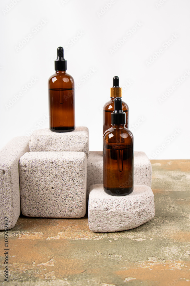Amber Glass Dropper Bottles on Textured Stone Pedestals for Skincare Branding Amber Glass Dropper Bottles on Textured Stone Pedestals for Skincare Branding