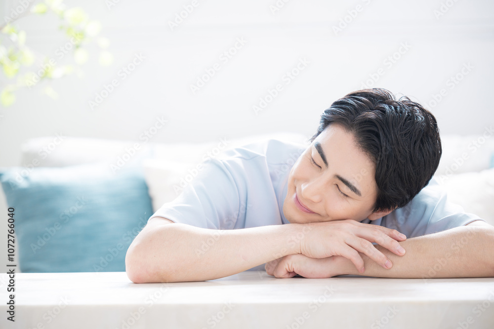 机でうたた寝をする若い男性　睡眠など眠りのイメージのクローズアップ