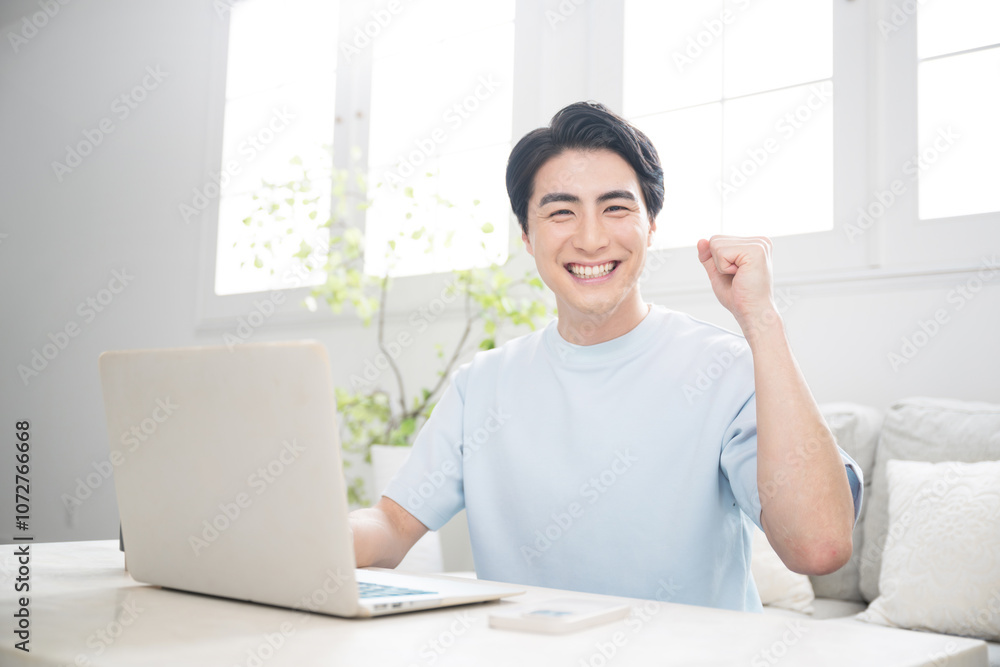 Smiling young man using a computer in a brightly lit room. Fresh camera gazes and guts of freelancers, engineers, designers, and other professionals. Smiling young man using a computer in a brightly lit room. Fresh camera gazes and guts of freelancers, engineers, designers, and other professionals.