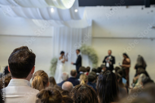 wedding ceremony celebrating marrage, with a wedding party crowd taking photos and videos of the party dancing and watching