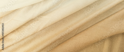 Close-up of a soft, brown fabric with gentle diagonal folds. Premium photo cloth background from top view for background.