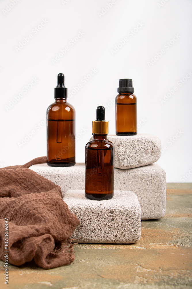 Amber Glass Bottles with Dropper and Screw Cap on Stone and Fabric Display Amber Glass Bottles with Dropper and Screw Cap on Stone and Fabric Display
