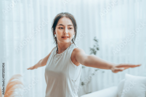 Wallpaper Mural Happy young Asian woman practicing yoga and shoulder stretching  in living room at home Torontodigital.ca