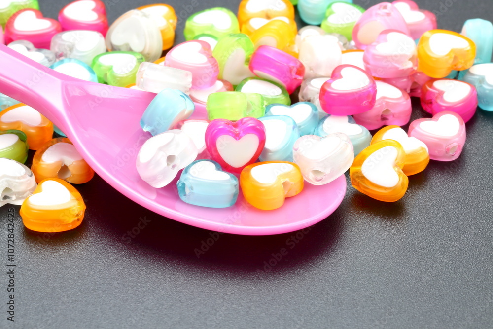 Colourful heart on a pink plastic spoon background giving a delightful vibes . Concept for food for the heart Colourful heart on a pink plastic spoon background giving a delightful vibes . Concept for food for the heart