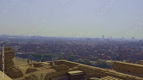 A city skyline with buildings and a plane flying over it