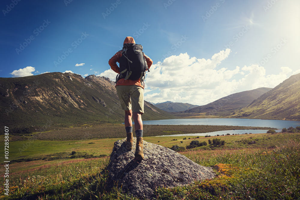 Woman hiker wearing leather boots hiking on high altitude grassland mountain top rock Woman hiker wearing leather boots hiking on high altitude grassland mountain top rock