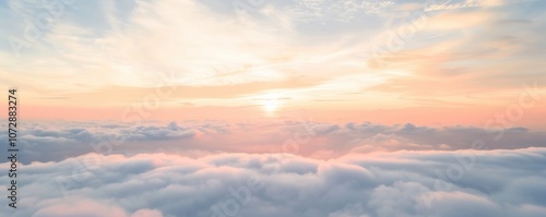 Serene sunset above fluffy clouds in pastel colors.