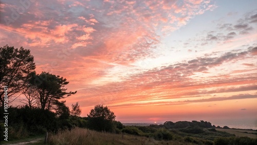 Softly glowing sky with shades of coral and peach, as the sun dips slowly into darkness, sunset, soothing