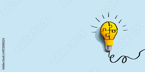 Jigsaw puzzle with a yellow light bulb - Flat lay