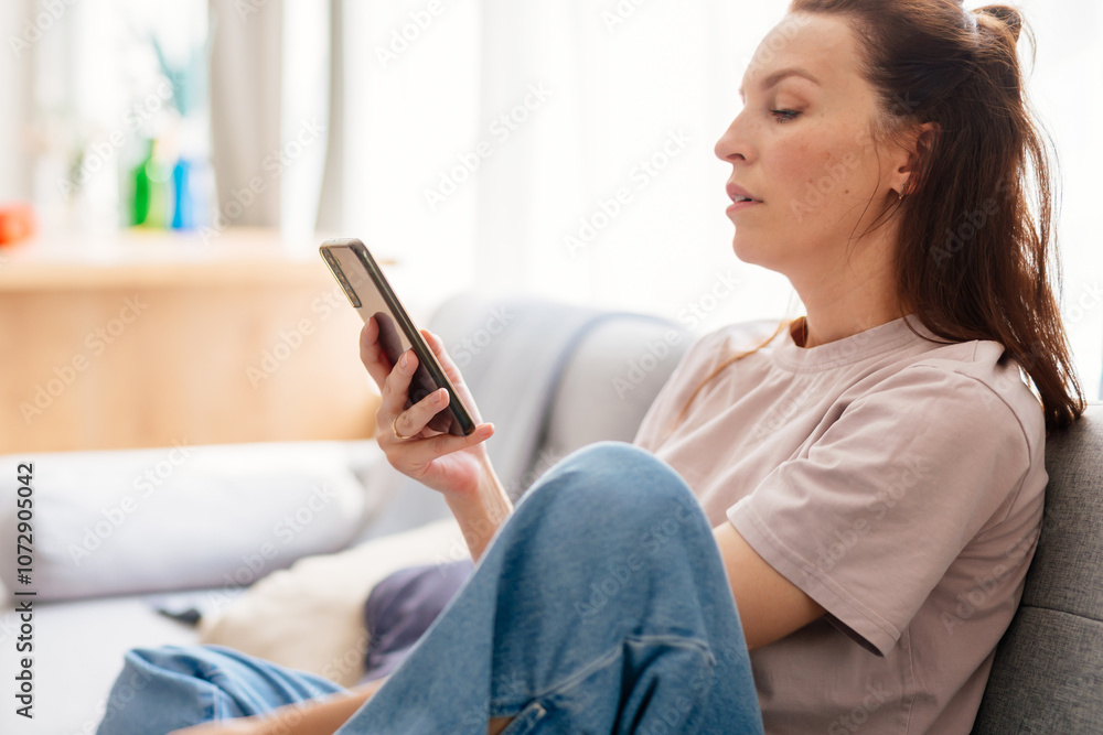 Woman using mobile phone at home Woman using mobile phone at home
