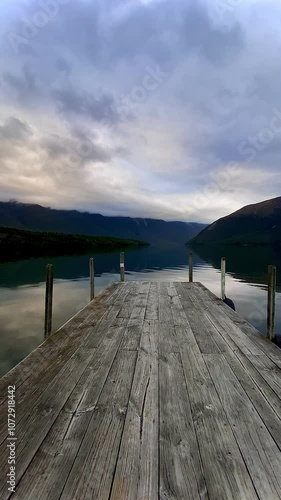 Lake Rotoiti wharf with beautiful landscapes on the background. Wooden pier on the lake