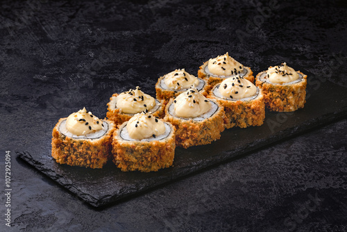 Japanese rolls, sushi fried tempura salmon and cream cheese on black background.