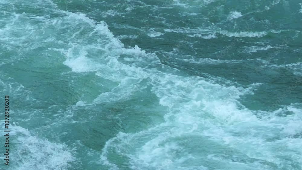 Dynamic close-up of fast-moving, turbulent water with visible rapids emphasizing energy, nature and the power of flowing water in a river or waterfall Dynamic close-up of fast-moving, turbulent water Dynamic close-up of fast-moving, turbulent water with visible rapids emphasizing energy, nature and the power of flowing water in a river or waterfall Dynamic close-up of fast-moving, turbulent water