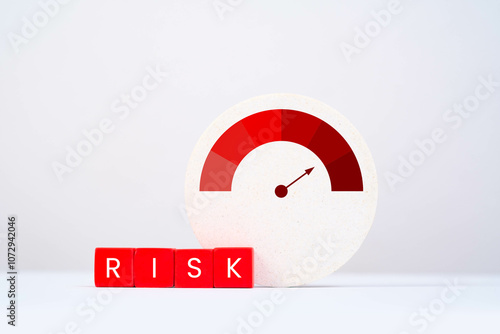 A visual representation of risk measurement, featuring a gauge and blocks spelling 'RISK' against a minimalist background. photo