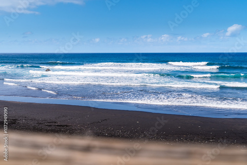 Dark sand beach with beautiful waves in the background