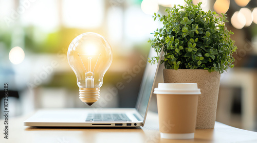 Innovative workspace with a glowing lightbulb, laptop, and coffee, symbolizing creativity and productivity. photo