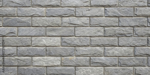 A close up of a grey brick wall with a rough, textured surface and a staggered pattern.