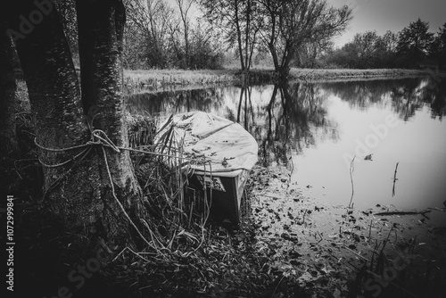 Obraz na płótnie an old rowing boat lies on the shore of a lake in autumn w salonie