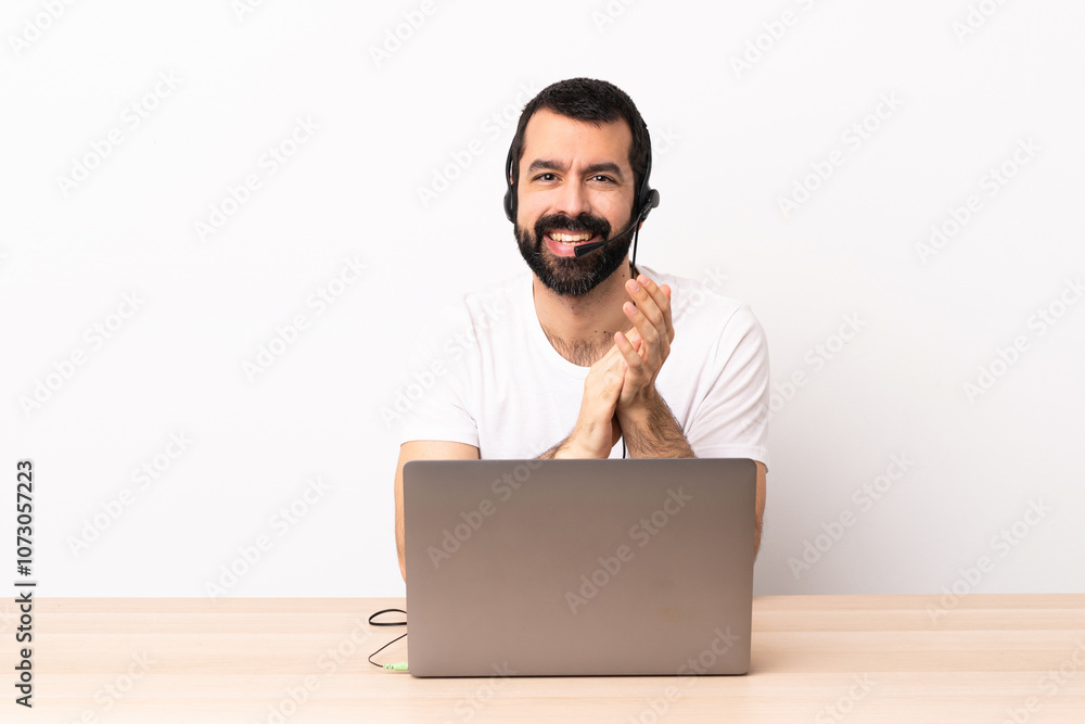 Telemarketer caucasian man working with a headset and with laptop applauding after presentation in a conference. Telemarketer caucasian man working with a headset and with laptop applauding after presentation in a conference.