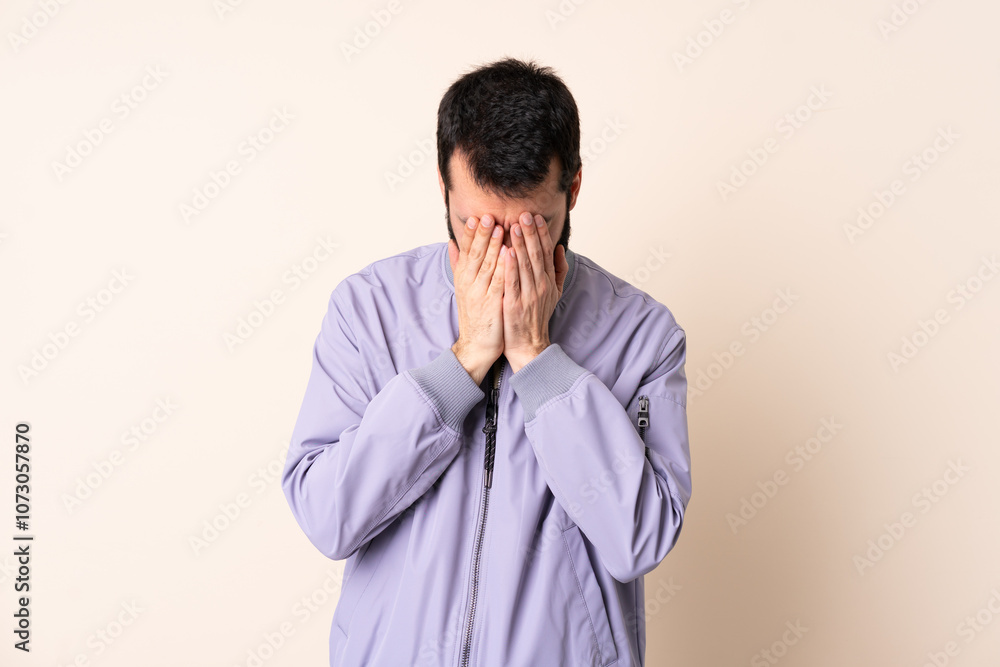 Caucasian man with beard wearing a jacket over isolated background with tired and sick expression Caucasian man with beard wearing a jacket over isolated background with tired and sick expression