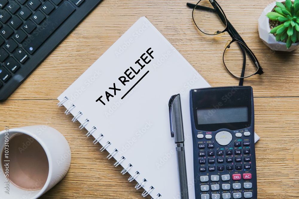 Tax Relief text in notepad with office accessories. Tax Relief text in notepad with office accessories.
