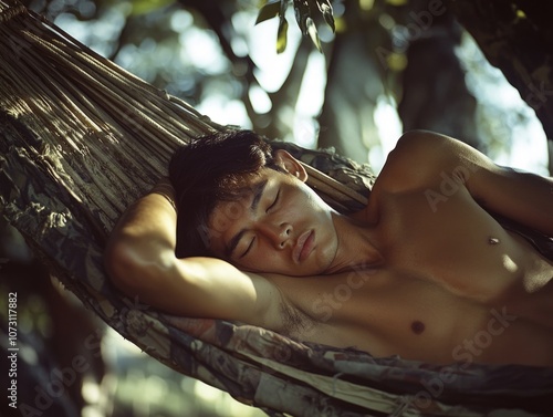 Asian man sleeping in a hammock suspended between two trees. The outdoor setting suggests a relaxed, vacation or adventure theme.