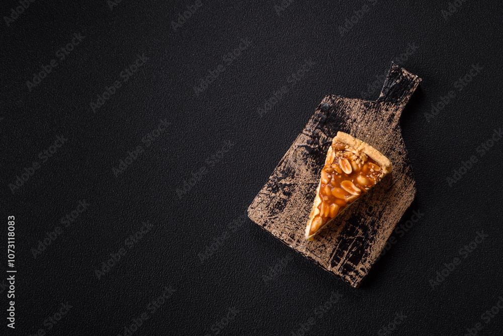Delicious fresh cheesecake caramel peanut cake with cream and nuts on a ceramic plate on a dark concrete background Delicious fresh cheesecake caramel peanut cake with cream and nuts on a ceramic plate on a dark concrete background