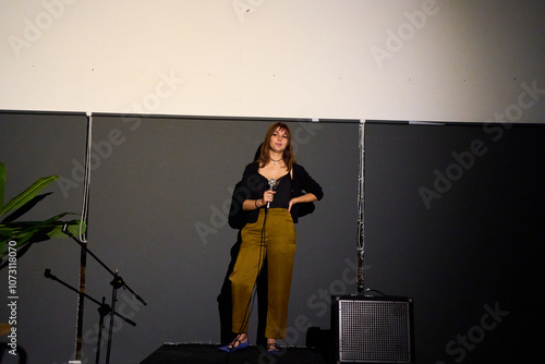 Female performer delivering a monologue on stage in an alternative theater with audience photo