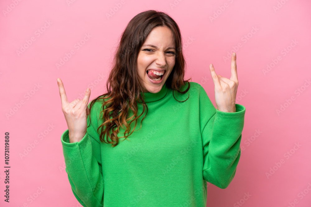 Young caucasian woman isolated on pink background making horn gesture Young caucasian woman isolated on pink background making horn gesture